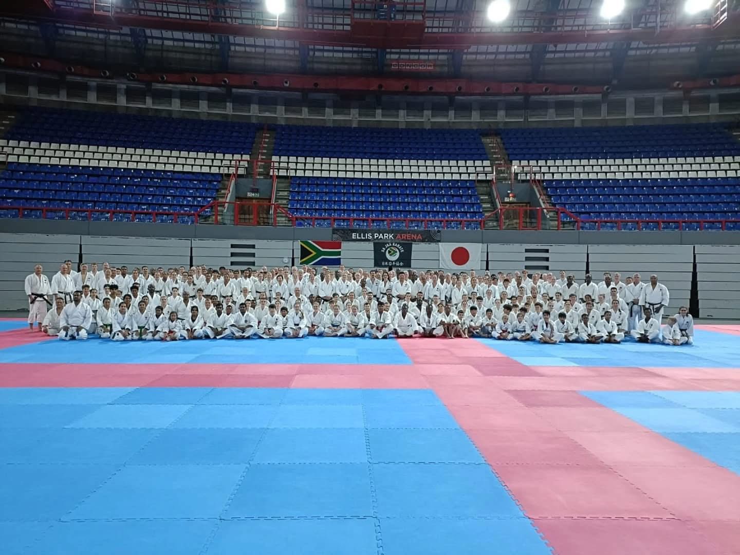 Team group photo at Ellis Park Arena with South African and Japanese flags